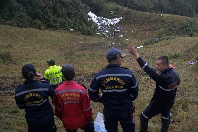 Rescuers gesture near the wreckage of the LAMIA airlines charter plane carrying members of the Chapecoense Real football team that crashed in the mountains of Cerro Gordo, municipality of La Union, on November 29, 2016. A charter plane carrying the Chapocoense Real football team crashed in the mountains in Colombia late Monday, killing as many as 75 people, officials said.  / AFP PHOTO / Raul ARBOLEDA